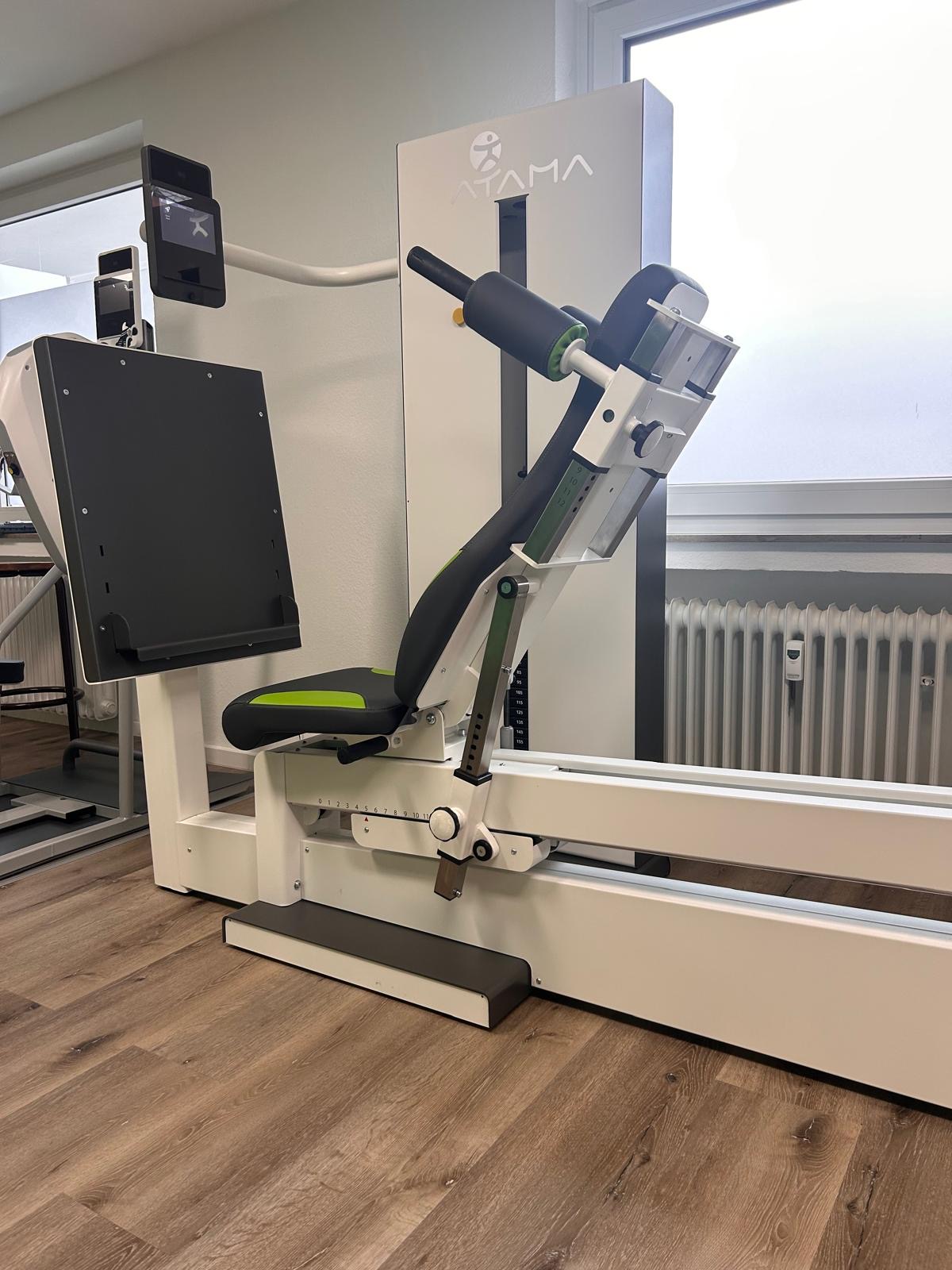 Ein modernes Fitnessgerät mit schwarzem Sitz, grünen Akzenten und weißen Elementen