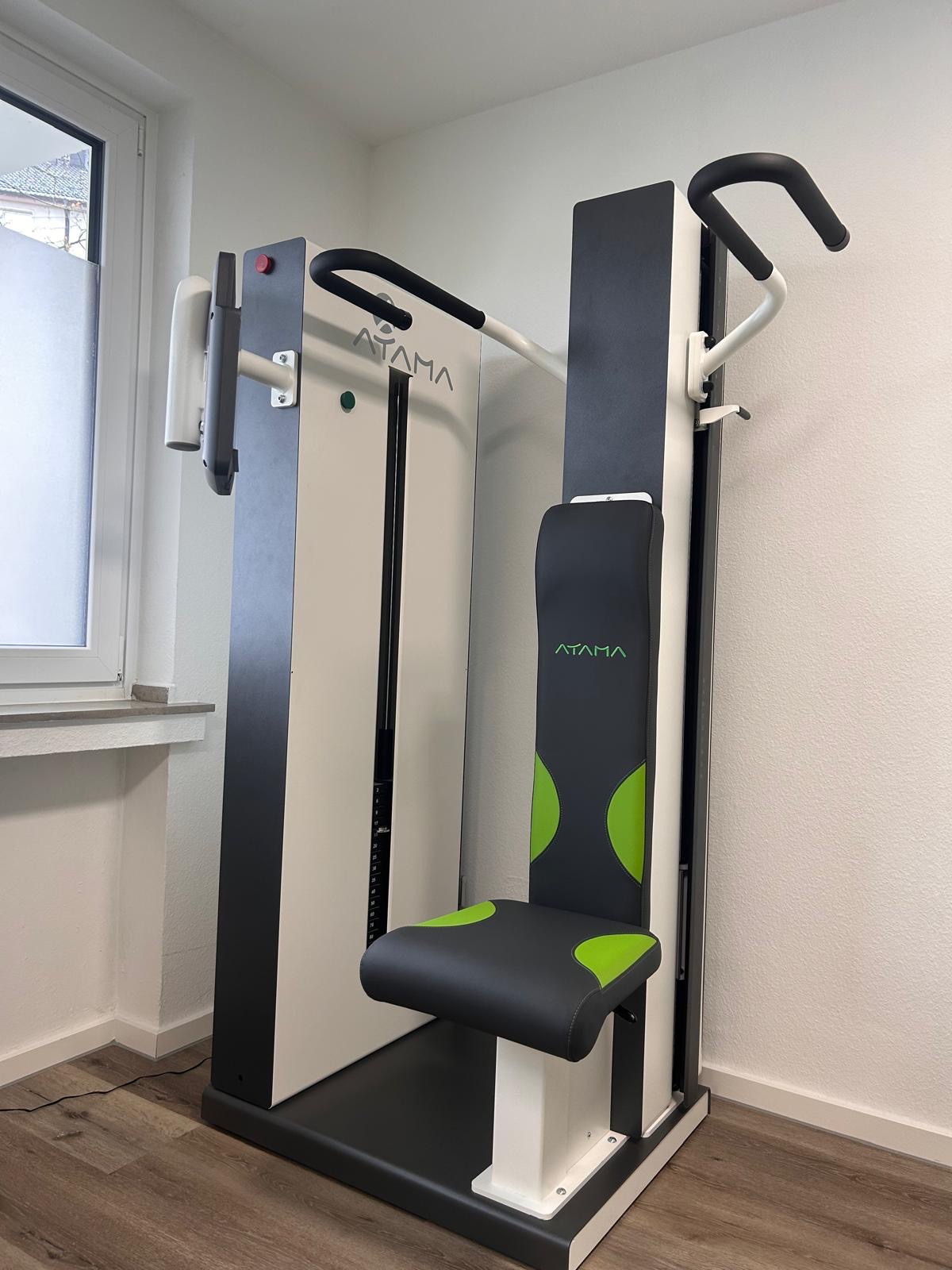 Ein Fitnessgerät mit schwarzem und grünem Sitz steht in einem hellen Raum
